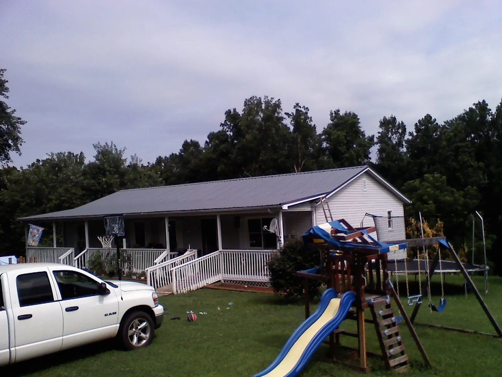 Dark metal roof on a country home with a full length front porch in Gainesville
