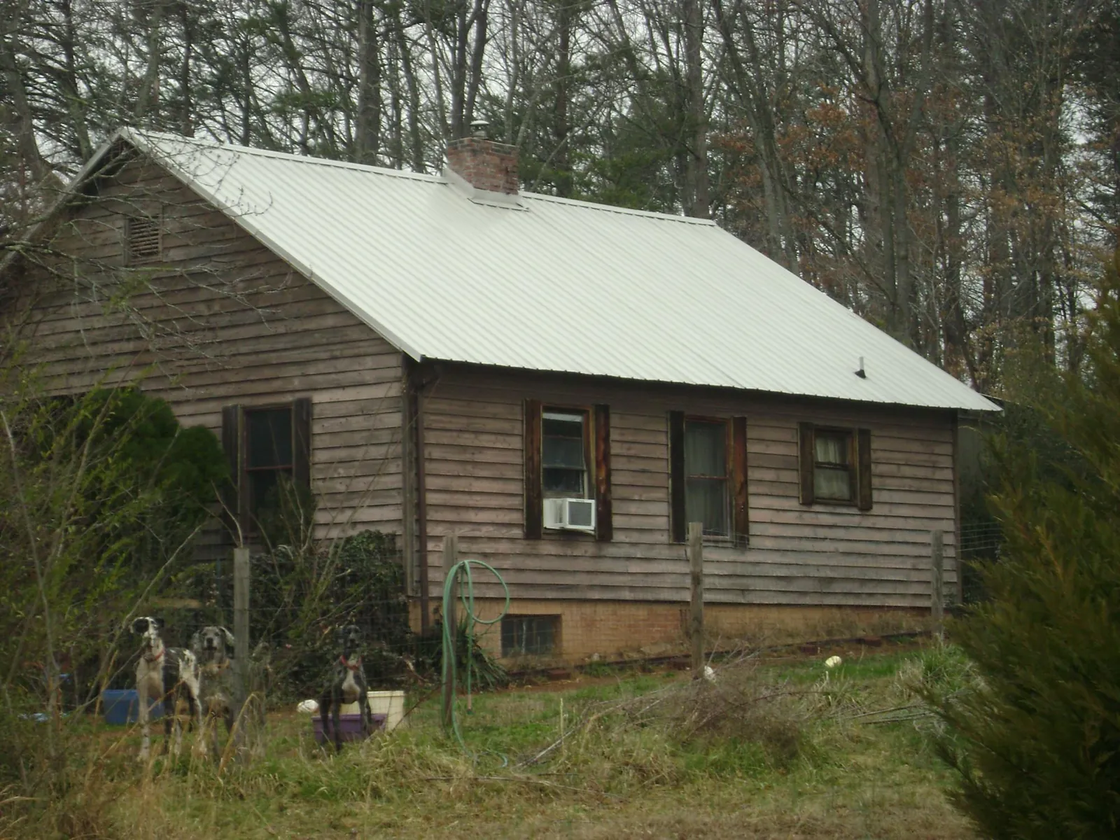 White metal roof on an old wood sided farmhouse, from a Metal Roof Installation job in Gainesville